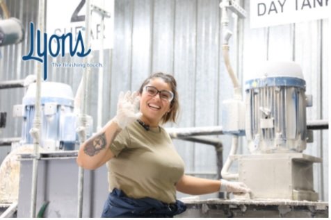 Lyons employee smiling and waving in factory warehouse